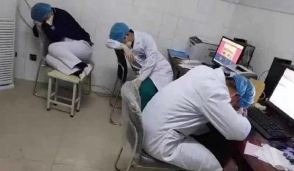 업무를 마치고 사무실에서 의자에 앉은 채 잠을 청하고 있는 중국 의료진./인민일보