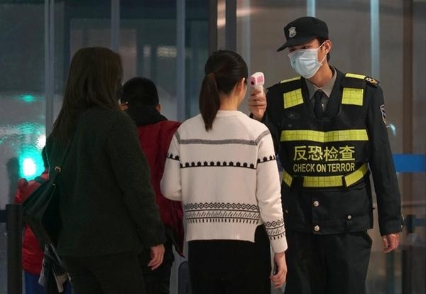 신종 코로나바이러스 진원지인 중국 후베이성 우한의 톈허 국제공항에서 지난달 21일 한 검역관이 우한을 떠나는 여행객들의 체온을 측정하고 있다. /연합뉴스
