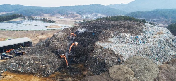 지난달 17일 오전 경북 의성군 단밀면에 있는 쓰레기 산에서 포클레인들이 삽질할 때마다 뿌연 연기가 피어오르고 있다. 유기물이 썩으면서 생기는 메탄가스와 수증기 등이 섞여 나오는 것이다. 이곳에는 폐기물 11만t이 3층 건물 높이만큼 쌓여 있다./의성=고운호 기자