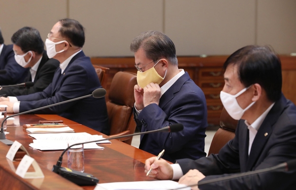 문재인 대통령이 지난 19일 청와대에서 열린 우한 코로나 대응 논의를 위한 비상경제회의에서 발언을 마친 뒤 마스크를 다시 쓰고 있다./연합뉴스