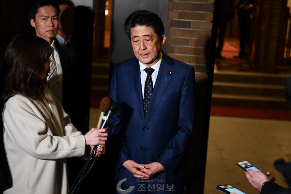 아베 신조 일본 총리가 24일 도쿄 총리관저 앞에서 기자들에게 도쿄 올림픽·패럴림픽을 1년 정도 연기하는 구상에 토마스 바흐 국제올림픽위원회(IOC) 위원장과 의견을 같이했다고 밝히고 있다./AP 연합뉴스