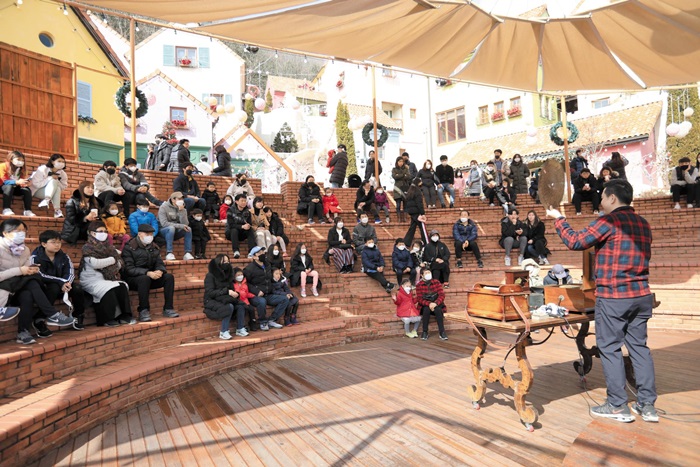 쁘띠프랑스를 찾은 관람객들이 야외공연장에서 오르골 시연 공연을 감상하고 있다.
