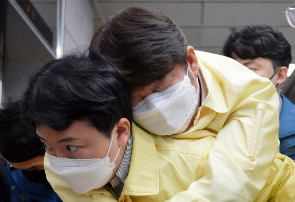 권영진 대구시장이 26일 오후 대구시의회 임시회의 이후 실신, 직원 등에 업혀 의회장을 빠져 나가고 있다. 권 시장은 임시회가 끝나고 더불어민주당 소속 시의원과 긴급 생계자금 지급 문제를 두고 마찰을 빚은 것으로 알려졌다. /뉴시스