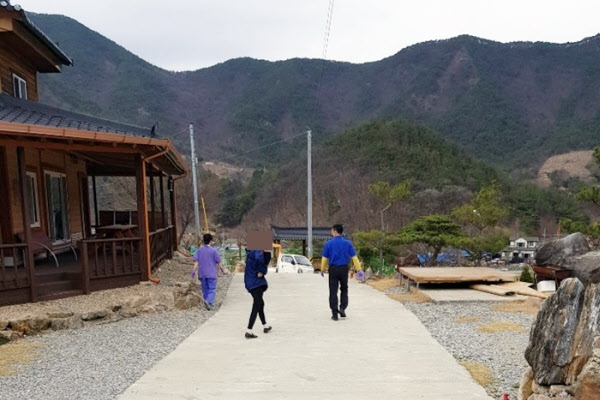 26일 오후 충북 보은군 장안면 서원리 병무청 사회복무연수센터에 격리 수용된 대구 코로나바이러스 감염증 확진자가 무단 이탈했다. 사진은 운영지원단 관계자와 의료진이 무단이탈한 20대 여성과 함께 센터로 돌아가는 모습/주민제공