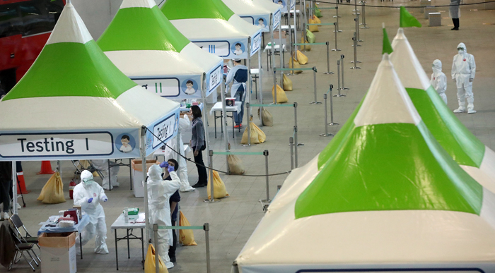 드라이브 스루 이어… 인천공항에 등장한 워킹 스루 진료소 - 26일 오후 인천국제공항 제2터미널 옥외 공간에 설치된 개방형 선별 진료소(오픈 워킹 스루형·Open Walking Thru)에서 영국 런던발 여객기를 타고 입국한 외국인이 코로나 바이러스 감염증 진단 검사를 받고 있다. 이 진료소는 벽면 없이 설치돼 바람이 많이 부는 공항의 특성을 이용하여 실시간으로 환기를 시키며 신속하게 진단 검사를 할 수 있다.