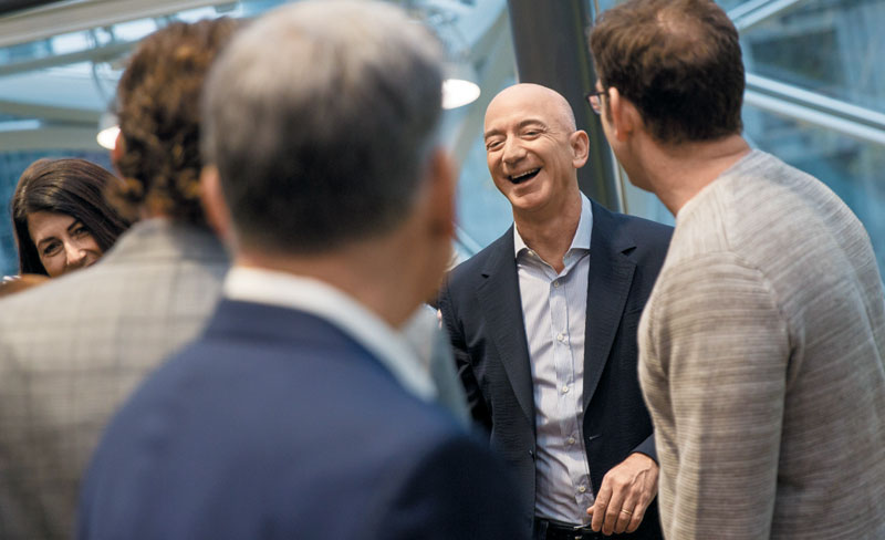 제프 베이조스 아마존 회장(오른쪽에서 두 번째)이 지난 2018년 미국 시애틀의 아마존 본사에서 직원들과 환담하며 웃고 있다. 