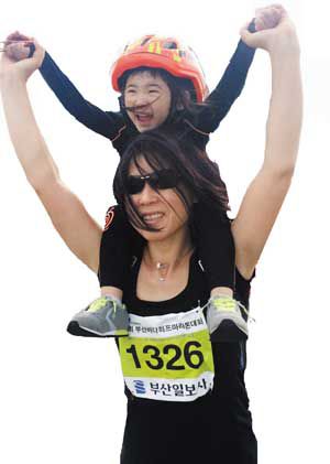 2015년 부산 해운대에서 열린 한 마라톤대회에서 김미애 당선인이 막내(입양한 딸)를 목말 태운 채 뛰고 있다.