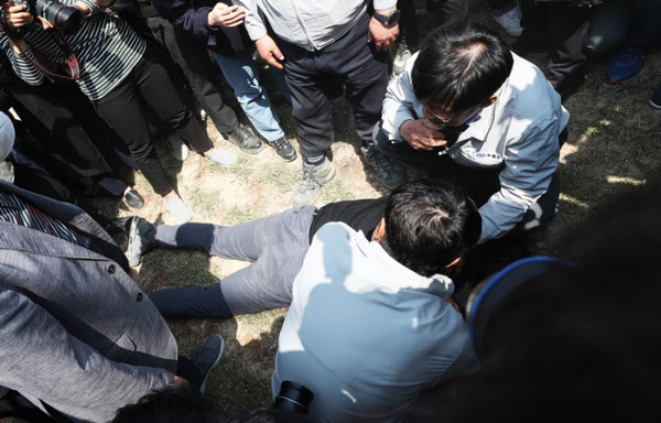 30일 오후 이천 화재현장 시공사 대표가 항의를 받으며 체육관을 나오다 쓰러지고 있다. /연합뉴스