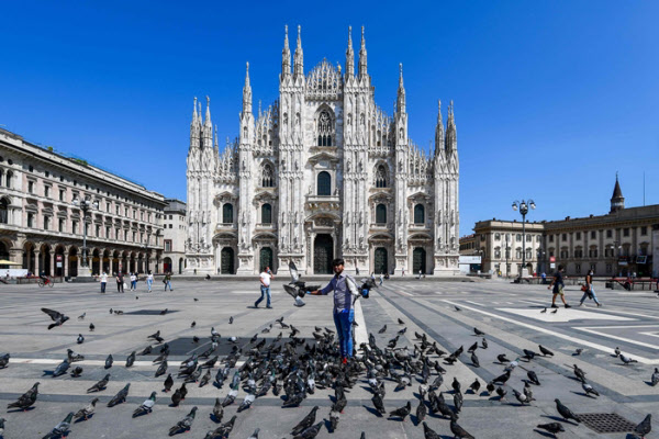 A man is feeding pigeons on Day 4 (local time) on the first day of the coronavirus blockade in Piazza Duomo in Milan, northern Italy. / AFP Yonhap News