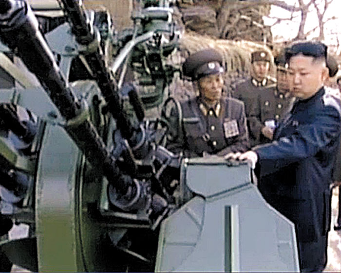 김정은 북한 국무위원장이 2014년 무렵 북한 군 시설에서 14.5㎜ 기관총(고사총)을 만지며 군 간부로부터 보고를 받고 있다.