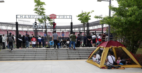 Fans gathered outside the fence of Kia Champions Field in Gwangju, where the opening ceremony for KIA and Kiwoom's 'Unattended' took place on the 5th. There are also fans watching the tents./Yonhap News