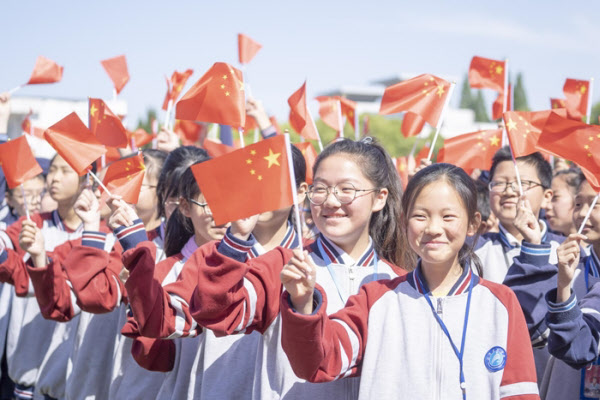 지난해 6월 장쑤성 교육부가 주최한 애국 행사에서 링링허우 세대인 중학생들이 국기를 흔들고 있다./양즈완바오