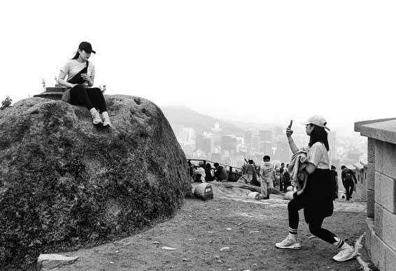 10일 오후 서울 종로구 인왕산 정상에서 한 여성이 다른 여성의 정상 등반 인증 사진을 찍어주고 있다. 올해 4월 북한산 탐방객이 작년 대비 78% 증가해 44만9068명을 기록했다.