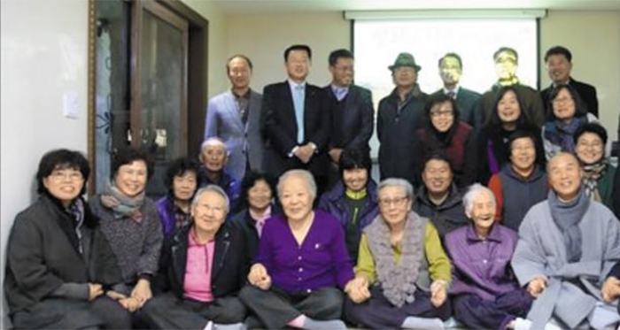 할머니들 눈물로… 도대체 무슨 짓을 했나 - 지난 2013년 11월 25일 경기도 안성시 금광면 ‘평화와 치유가 만나는 집’ 개소식 당시 기념사진. 이규민(맨 뒷줄 맨 오른쪽) 더불어민주당 국회의원 당선자가 윤미향(뒤에서 둘째 줄 오른쪽에서 둘째) 전 한국정신대문제대책협의회 대표에게 이곳을 소개한 것으로 확인됐다. 윤 전 대표의 남편 김삼석씨는 자신이 운영하는 온라인 매체 수원시민신문에 관련 기사를 실었으나 지금은 삭제된 상태다. 맨 앞줄 오른쪽 둘째부터 위안부 피해자인 고(故) 이순덕·고(故) 김복동·고(故) 안점순·길원옥 할머니.