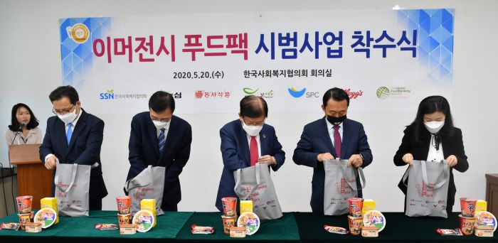 농심 김보규 상무(왼쪽부터), 동서식품 최상인 상무, 한국사회복지협의회 서상목 회장, SPC그룹 김범호 부사장, 농심켈로그 송혜경 상무가 이머전시 푸드팩을 포장하고 있다.(사진제공=한국사회복지협의회)
