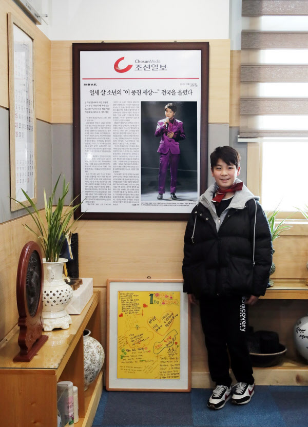 지난 3월 윤상기 하동군수 집무실 벽에 걸린 자신의 기사를 보고 기념촬영을 하고 있는 정동원군./ 하동군