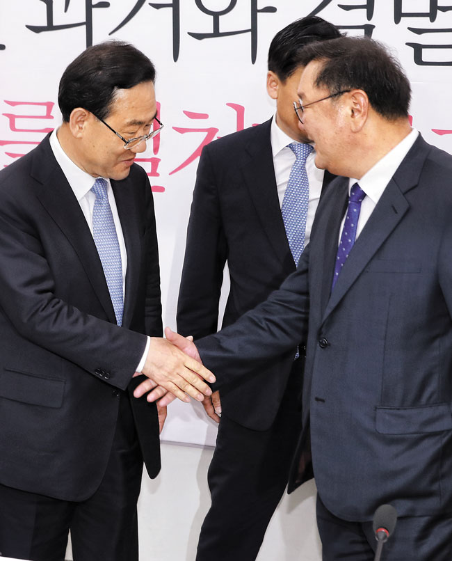 더불어민주당 김태년(오른쪽) 원내대표와 미래통합당 주호영 원내대표가 26일 국회에서 만나 악수하고 있다.