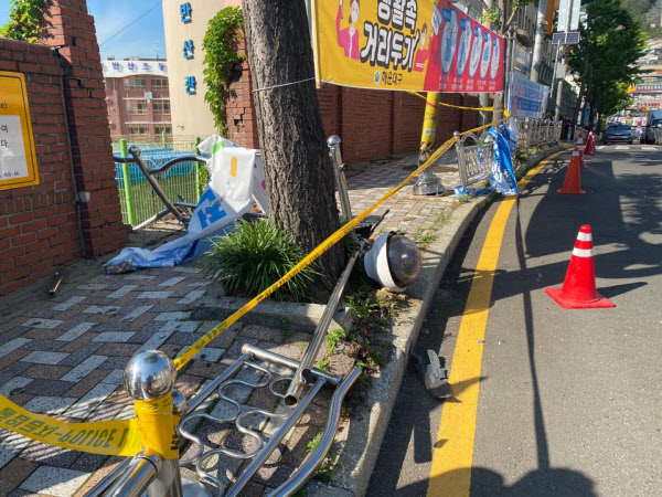 지난 15일 오후 부산 해운대구 재송동 한 초등학교 앞에서 다른 승용차와 충돌한 아반떼 차량이 갑자기 인도 위로 뛰어들어 길가던 5세 여아 모녀를 친 뒤 3m 아래에 쯤 아래에 있는 학교 화단에 떨어지기 전 허물어 버린 인도 가드레일과 학교 옆 담장 모습. /부산경찰청제공