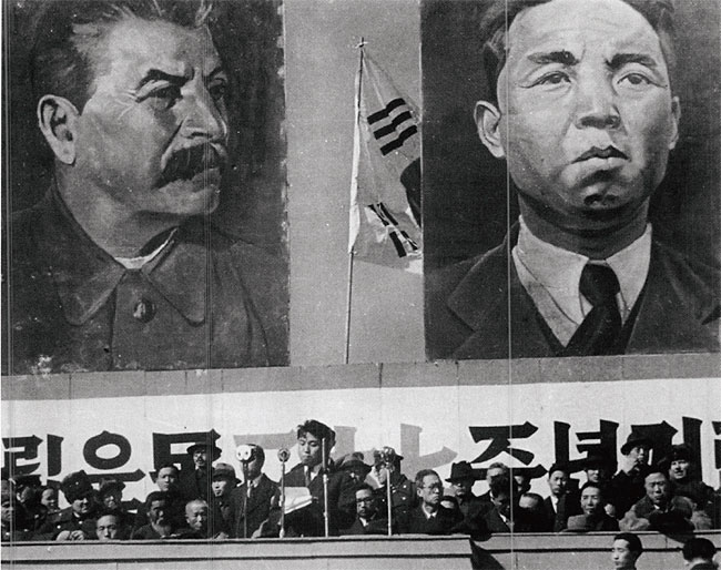 1946년 3월 1일 북한 평양에서 열린 삼일절 기념식 때 자신과 소련공산당 서기장 스탈린의 대형 초상화 아래서 연설하는 김일성 당시 북조선임시인민위원장(가운데). 뒤에 걸린 태극기가 이색적이다. photo 뉴시스