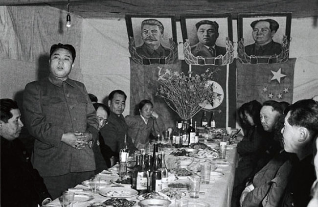 6·25전쟁 와중인 1951년 4월 북한을 찾은 중국인민위문단을 맞이하여 연회를 주재한 김일성 당시 조선인민군 총사령관. 뒤로 자신의 초상화와 함께 소련 스탈린(왼쪽), 중국 마오쩌둥(오른쪽)의 초상화와 국기가 걸려 있다. photo 바이두