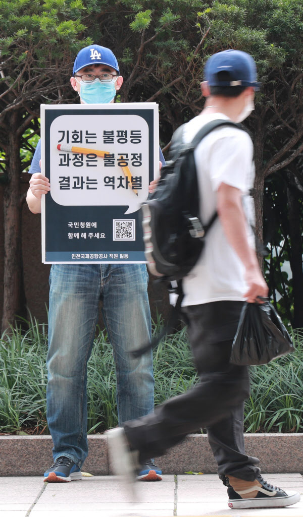 지난 26일 서울 광화문역 인근에서 인천공항공사 직원들이 보안검색원 정규직 논란 1인 시위를 하고 있다. /이태경 기자