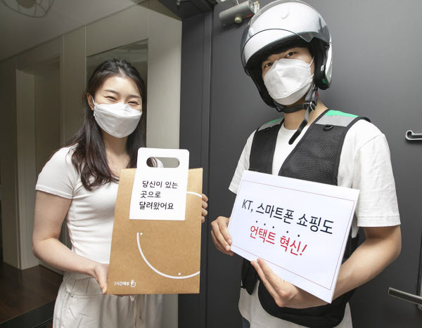 KT 고객이 자택에서 ‘1분주문 & 1시간배송’ 서비스를 이용해 주문한 핸드폰을 부릉 라이더로부터 배송 받고 있다.