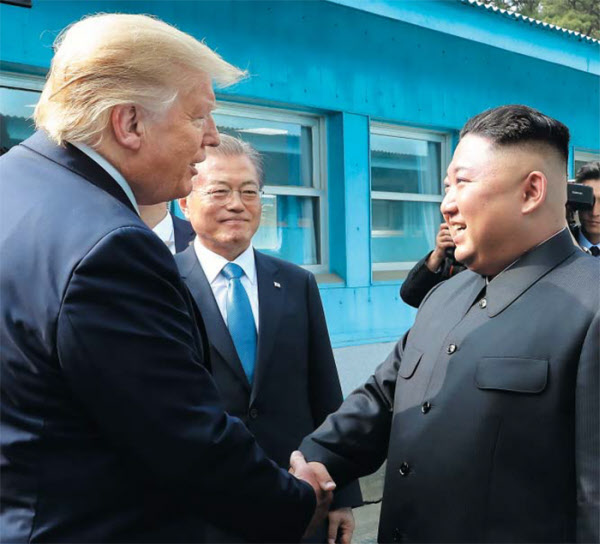 도널드 트럼프(왼쪽) 미국 대통령과 김정은(오른쪽) 북한 국무위원장이 지난 2019년 6월 판문점에서 만나 악수하고 있는 모습. 가운데 문재인 대통령의 모습이 보인다. /조선중앙통신 연합뉴스