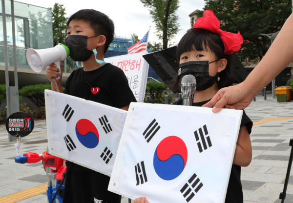 지난 25일 토요일 오후 어김없이 남매 이정이군과 정아양이 엄마와 함께 1인시위 현장에 나와서 애국가를 부르고 있다./이진한기자