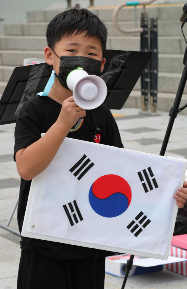 애국가 맘의 첫째 이정이군이 태극기와 손마이크를 들고 25일 애국가를 부르고 있다.동요을 좋아하는 이군은 애국가는 물론 6.25노래도 부를 줄 안다./이진한기자