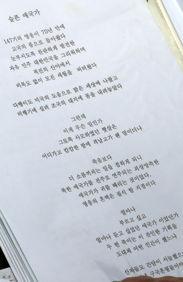6.25전쟁 70주년 '참전용사 유해봉환' 행사에서 일어난 북한국가 연주 논란에 분노한 한 시인이‘슬픈 애국가’라는 제목으로 시를 지어 애국가 맘에게 건넨 작품을 애국가 맘이 1인시위하는 동안 낭독하고 있다,/이진한기자