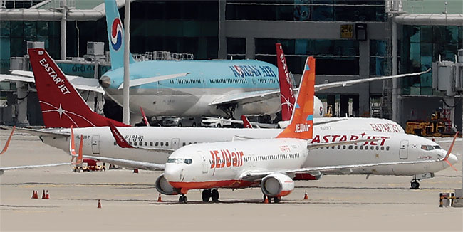 지난 7월 14일 오전 인천국제공항 여객터미널에 제주항공 비행기와 이스타항공 비행기가 멈춰 서 있다. photo 뉴시스