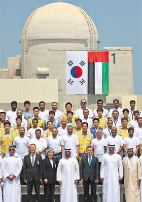 한국이 2009년 처음 수출한 아랍에미리트 바라카 원전 앞에서 2018년 문재인 대통령(맨 앞줄 오른쪽에서 셋째)이 UAE 관계자들과 함께 기념촬영을 하는 모습. /연합뉴스