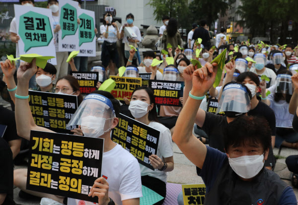 1일 서울 중구 청계천로 일대에서 열린 '투명하고 공정한 정규직 전환 촉구 문화제' 참가자들이 '기회는 평등하게' 등이 적힌 손팻말과 연두색 종이 비행기를 들어 보이고 있다. /뉴시스