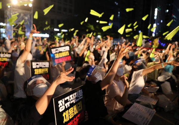 1일 서울 중구 청계천로 일대에서 열린 '투명하고 공정한 정규직 전환 촉구 문화제' 참가자들이 '공정한 과정'을 의미하는 연두색 종이 비행기를 하늘로 날려 보내고 있다. /뉴시스