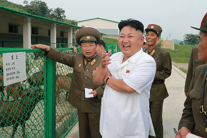 김정은 노동당 제1비서가 지난 2014년 8월 21일 북한군 염소 우리 앞에서 담배를 손에 낀 채 웃으며 군인들의 설명을 듣고 있다. 