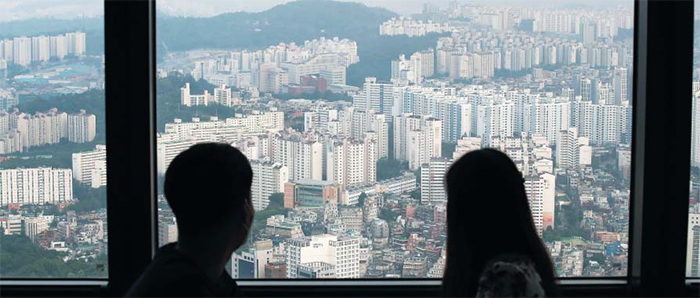 20일 서울 여의도 63빌딩 60층 전시 공간인 ‘63아트’를 찾은 이들이 주변 아파트 단지를 바라보고 있다. 여의도 주변 마포 아파트 단지 중에선 20평형대 전셋값이 7억원을 넘는 곳들이 잇따라 나오고 있다. 정부가 지난달 말 전·월세 상한제, 계약갱신청구권제를 담은 주택임대차법을 시행한 후 서울에선 매물이 사라지고 가격이 급등하는 ‘전세 대란’이 현실화하고 있는 것이다.