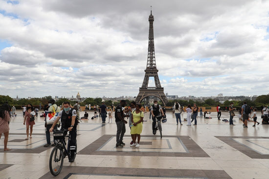 24일 에펠탑이 내려다보이는 파리 트로카데로 광장에서 경찰관들이 자전거를 타고 다니며 마스크를 썼는지 여부를 단속하고 있다./AFP 연합뉴스