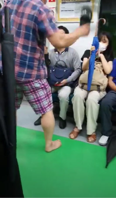 27일 오전 A씨가 자신이 신고 있던 슬리퍼를 벗어서 마스크 착용을 요구하는 승객의 얼굴을 향해 휘두르고 있다. /유튜브 캡처