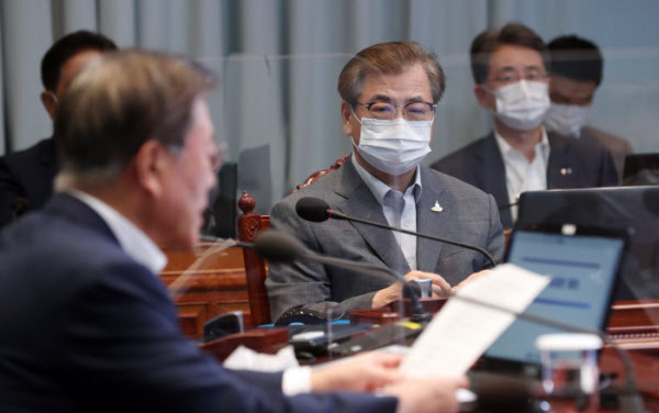 After self-isolation, Blue House national security officer Seo-hoon listens to President Moon Jae-in's remarks at a chief and advisers meeting held at the Blue House on the 31st. / Yunhap news