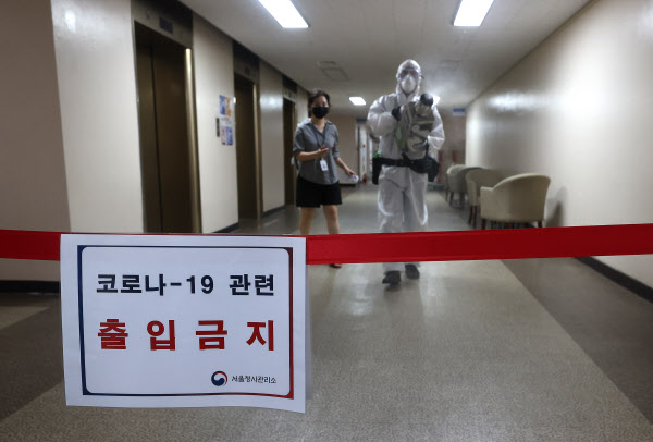 지난 26일 오전 정부서울청사에서 코로나바이러스 감염증 확진자가 나와 방역 관계자가 소독을 하고 있다./뉴시스