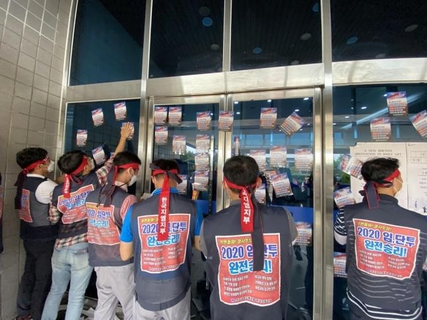 지난 14일 한국GM 노조가 인천 부평 한국GM 사옥에서 카허 카젬 사장을 비롯한 임원들을 비판하는 유인물을 붙이고 있다. /금속노조 한국GM 지부