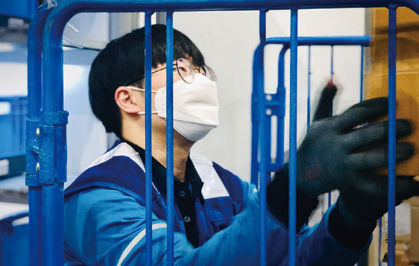 쿠팡 물류센터에서 한 직원이 마스크를 쓰고 일하고 있다. / 쿠팡