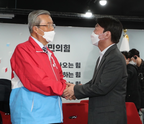 4ㆍ7 재보궐 선거에서 국민의힘 오세훈 서울시장 후보의 당선이 확실해진 8일 자정께 서울 여의도 당사 국민의힘 개표상황실에서 김종인 비상대책위원장(왼쪽)과 국민의당 안철수 대표가 손을 맞잡고 있다. /연합뉴스