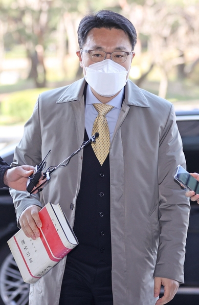 김진욱 공수처장이 8일 한손에 '형법각론' 책을 들고 정부과천청사에 출근하고 있다./연합뉴스