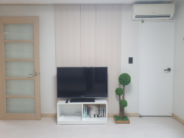 [땅집고] TV와 에어컨을 갖춘 거실. 호스트는 화이트 톤으로 리모델링했다고 설명했다. /단단홈즈