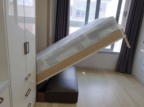 [땅집고] 벽면 붙박이장에서 내려오는 폴딩베드. 호스트는 낮에는 접어 거실로 쓸 수 있다고 설명했다. /단단홈즈