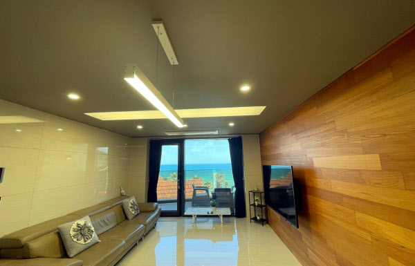 [땅집고] 제주 제주시 조천읍 함덕리 서우봉 인근 단기임대 주택 내부. 거실 전면 창을 통해 바다를 조망할 수 있으며, 소파와 TV 등 생활시설을 갖추고 있다. /단단홈즈